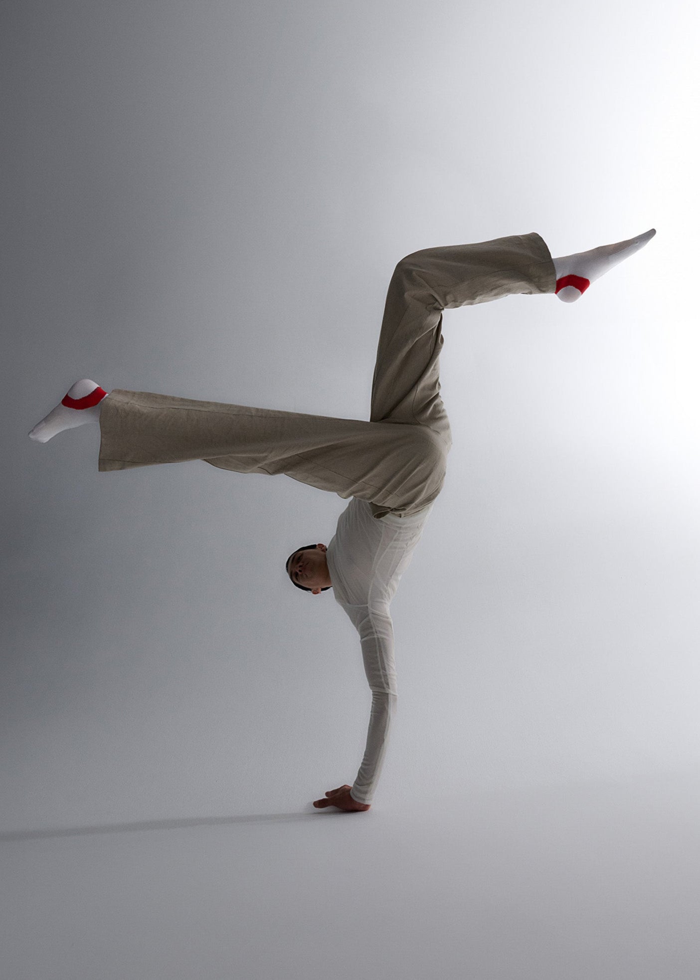Dancer doing hand stand while wearing the target socks in White and Red