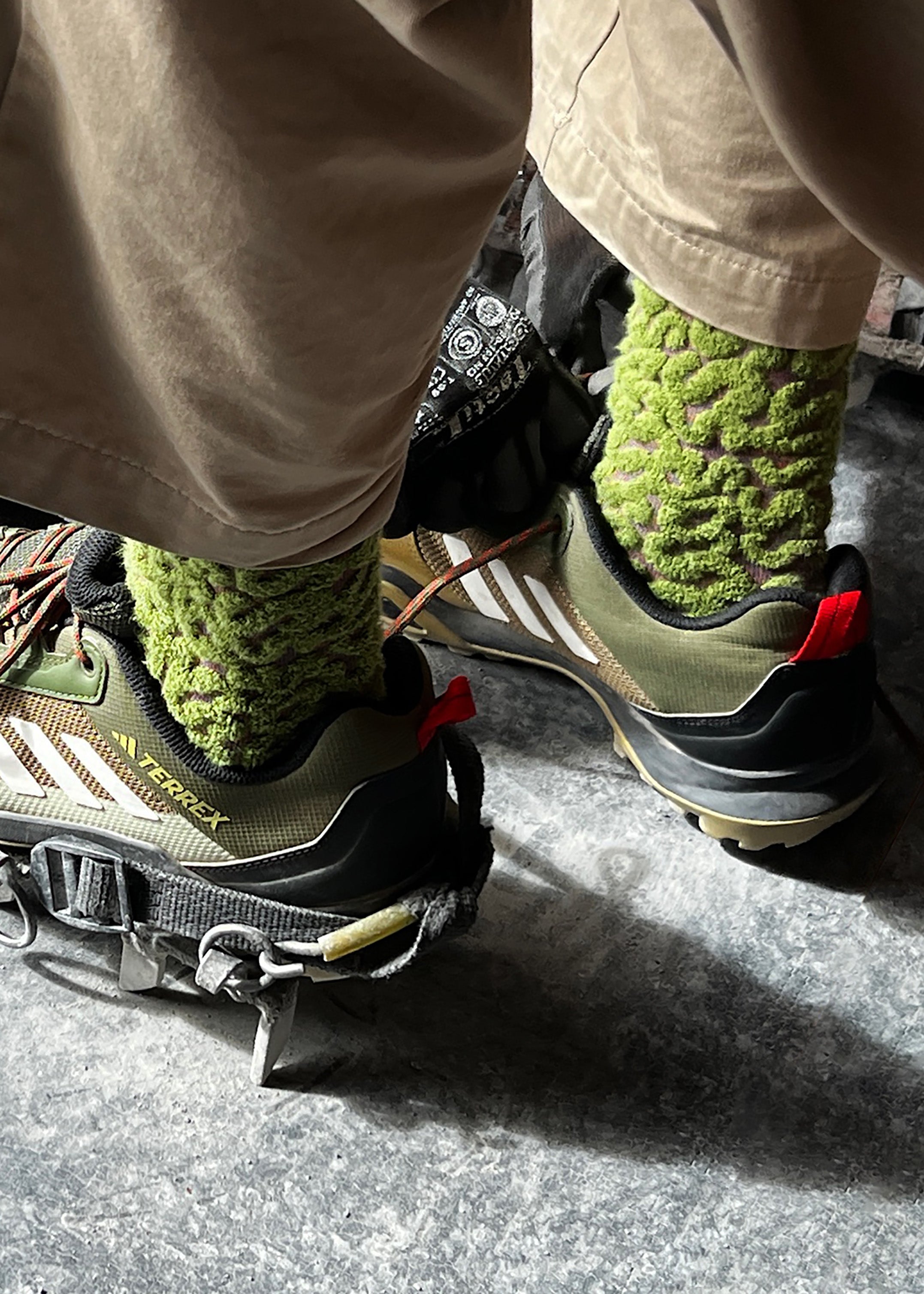 Close up of a person wearing the adidas hiking shoes with the Coral Cotton Terry Socks in Color Forest
