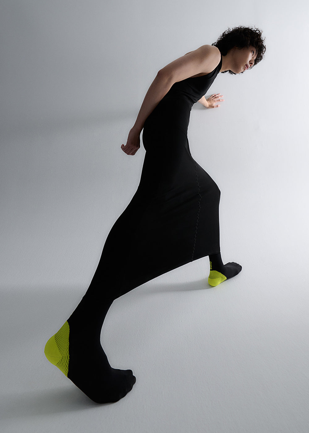 Model wearing all black with the Guard Semi Compression Socks in Color Black and Lime. 