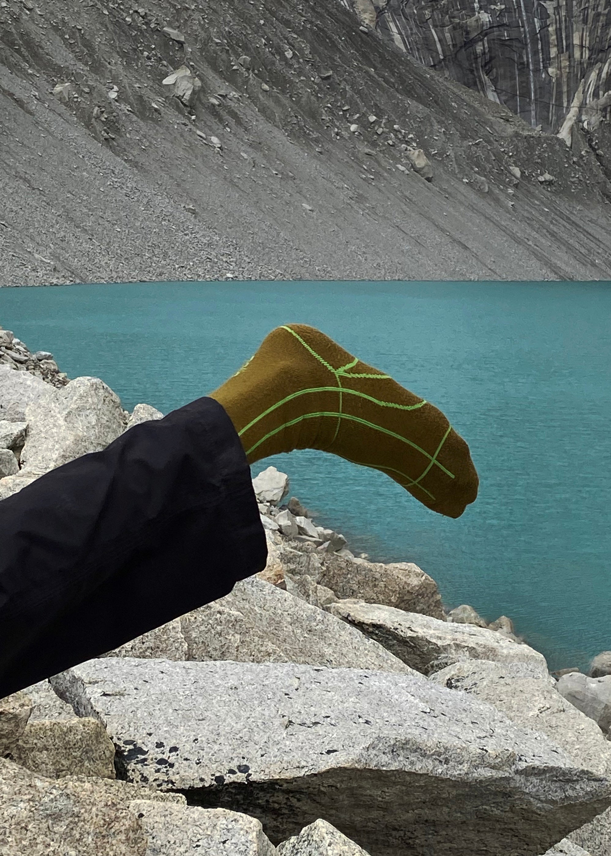 A close up of a person wearing the Line Max Wool Blend Socks in Color Dirt Gold and Algae