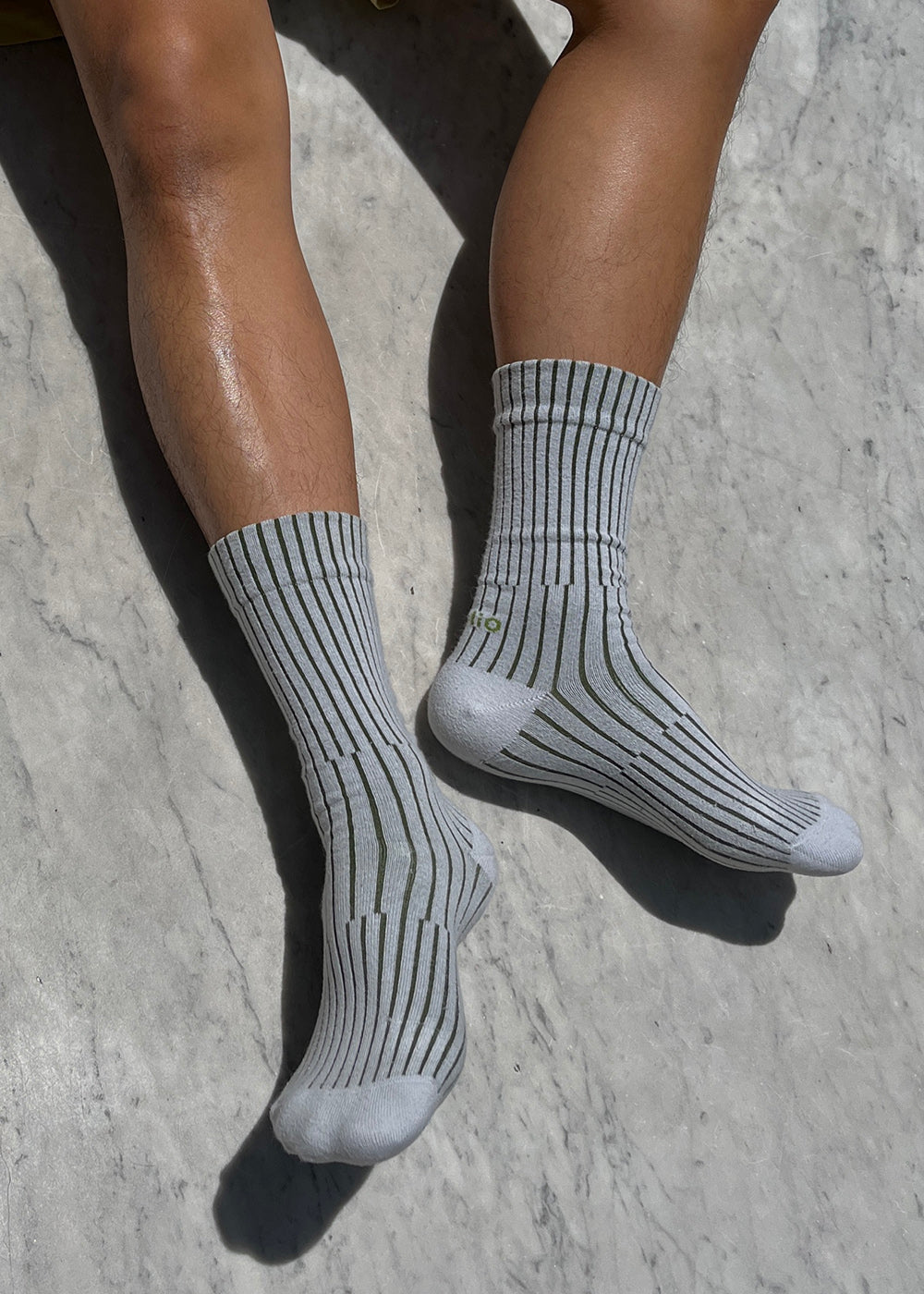 Close up of A person wearing the Split Rib socks in  Color Pale Grey and Moss